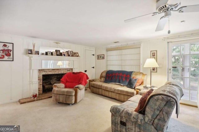 carpeted living room featuring ceiling fan and a fireplace