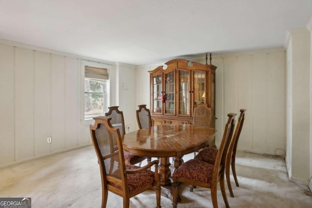 dining area featuring light colored carpet and ornamental molding