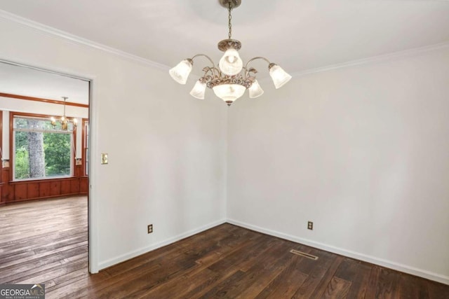 unfurnished room featuring dark wood-type flooring, crown molding, and a notable chandelier