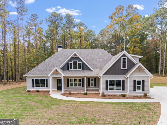 1797 Star Point Rd, Carrollton, GA 30116 - craftsman house featuring roof with shingles, a chimney, a front yard, board and batten siding, and covered porch