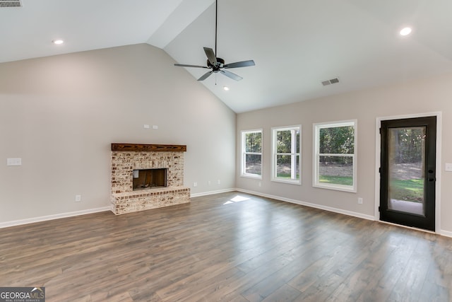 unfurnished living room featuring ceiling fan, a brick fireplace, high vaulted ceiling, and dark hardwood / wood-style flooring