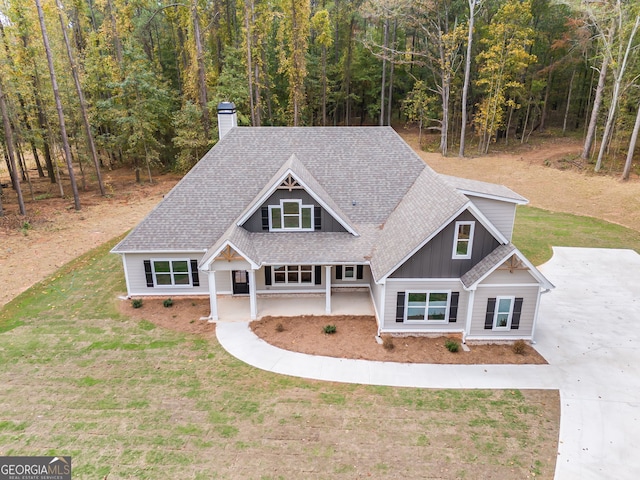 1797 Star Point Rd, Carrollton, GA 30116 - craftsman-style house featuring roof with shingles, concrete driveway, a chimney, board and batten siding, and a wooded view