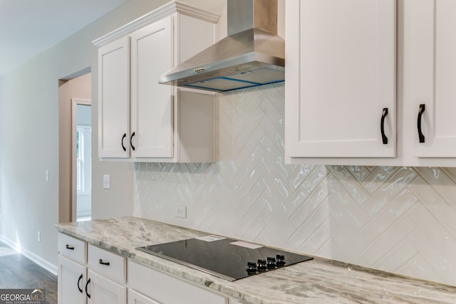 kitchen featuring white cabinetry, backsplash, black electric stovetop, and wall chimney exhaust hood