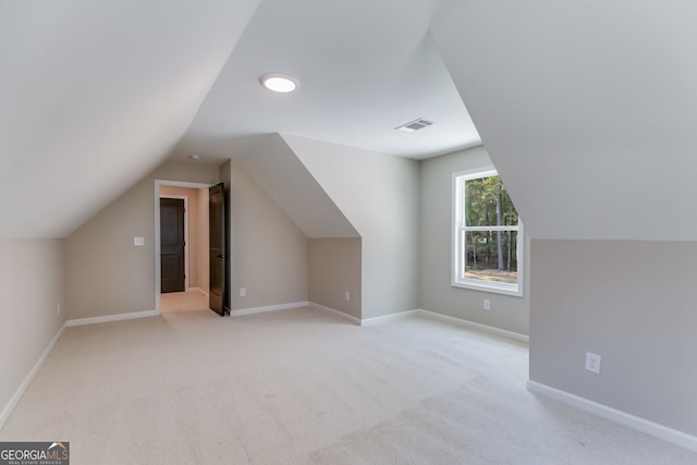 bonus room featuring light colored carpet and vaulted ceiling