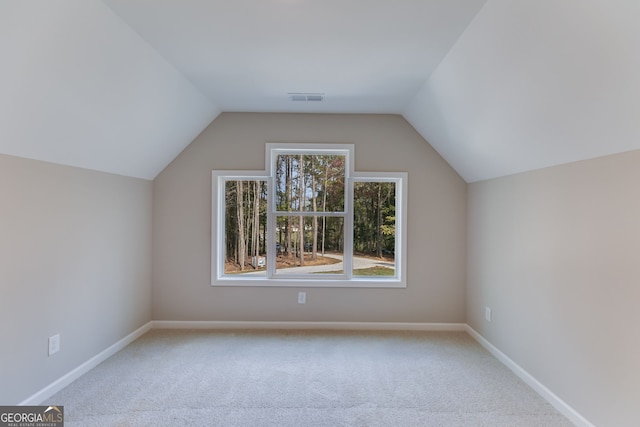 bonus room featuring lofted ceiling and light colored carpet