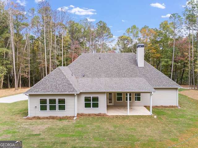 rear view of house with a yard and a patio area