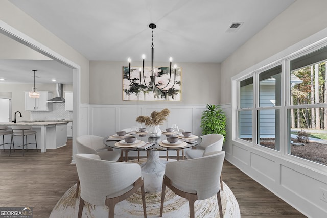 1797 Star Point Rd, Carrollton, GA 30116 - dining space with a chandelier, a decorative wall, dark wood-style flooring, and wainscoting