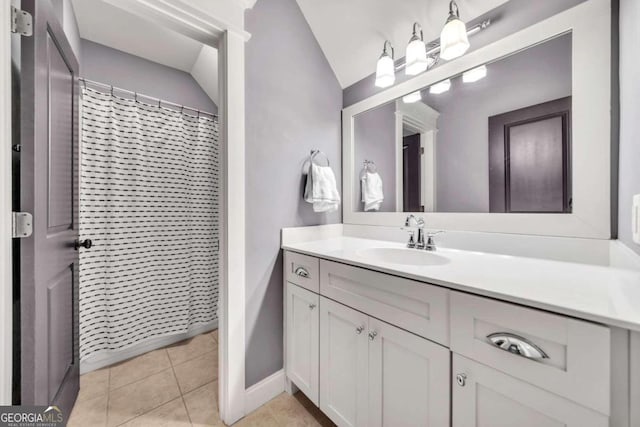 bathroom featuring vanity, lofted ceiling, and tile patterned flooring