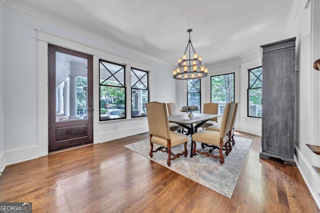 dining room featuring an inviting chandelier, crown molding, and dark hardwood / wood-style flooring