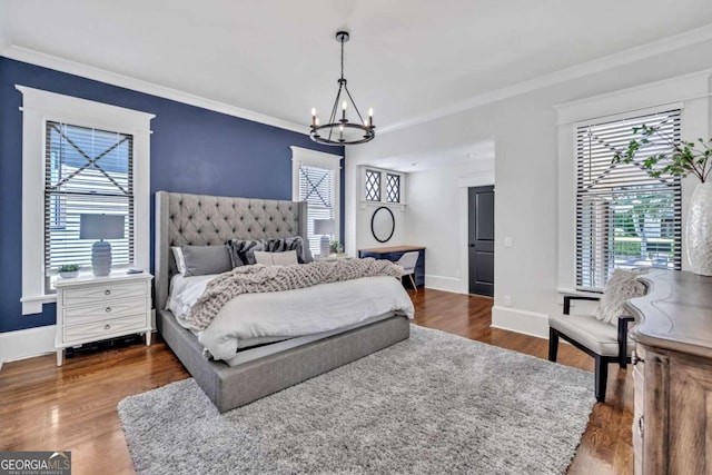 bedroom with an inviting chandelier, dark wood-type flooring, and ornamental molding