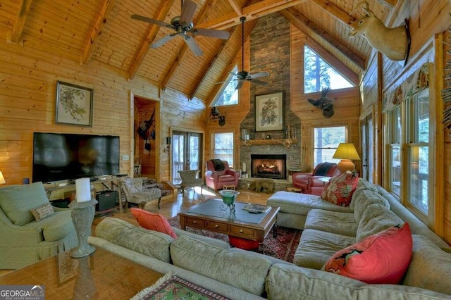 living room featuring beamed ceiling, wooden ceiling, high vaulted ceiling, and wood walls