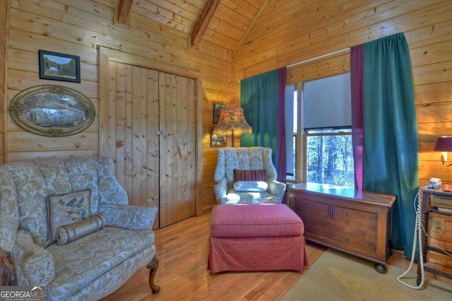 living area with wood ceiling, beam ceiling, high vaulted ceiling, wood walls, and light wood-type flooring