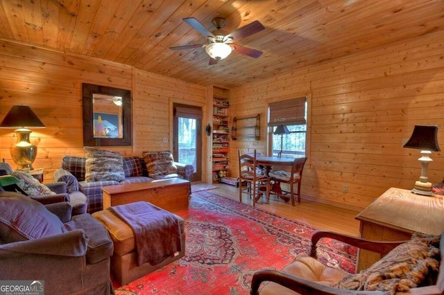 living room with ceiling fan, wood ceiling, wooden walls, and wood-type flooring