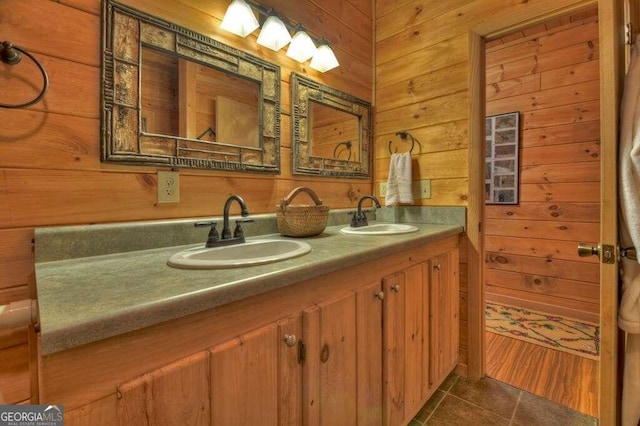 bathroom featuring vanity, tile patterned flooring, and wood walls