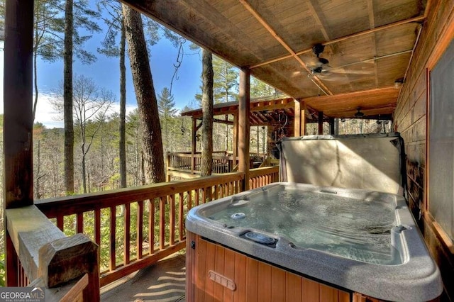 deck featuring ceiling fan and a hot tub