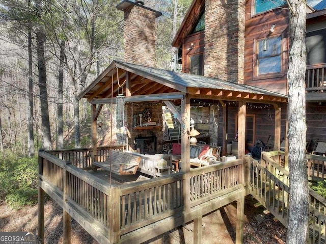 wooden deck featuring an outdoor stone fireplace