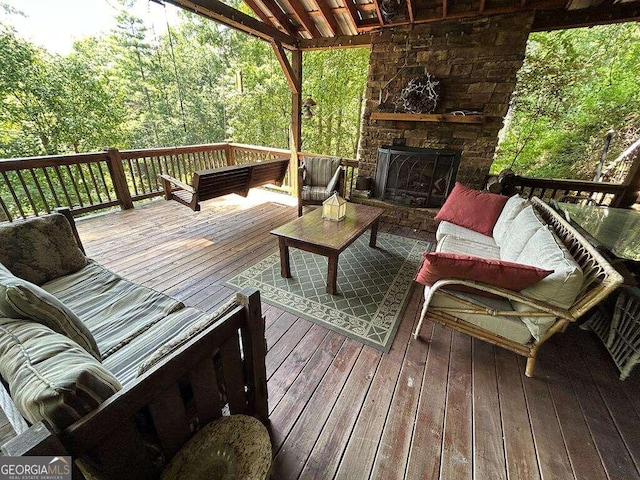 wooden terrace with an outdoor living space with a fireplace