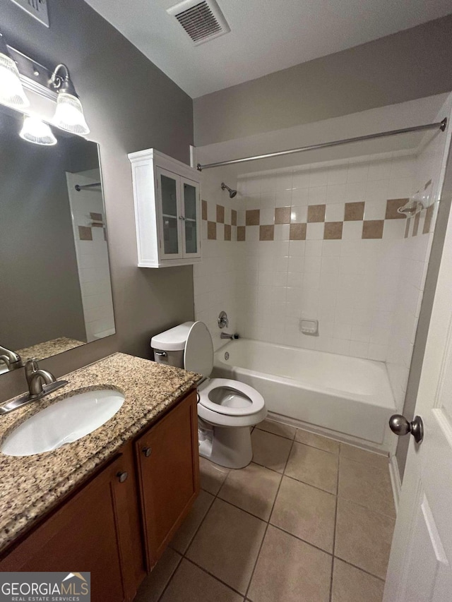 full bathroom featuring vanity, tiled shower / bath combo, toilet, and tile patterned floors