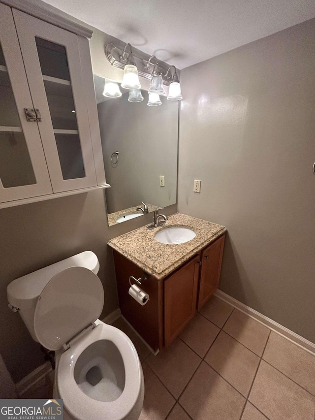 bathroom featuring tile patterned floors, toilet, and vanity