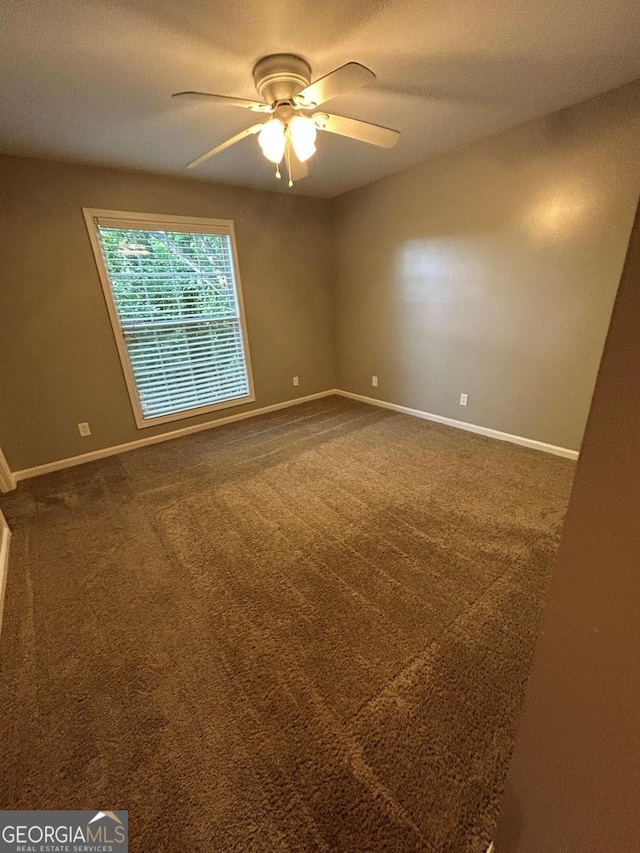 carpeted empty room featuring ceiling fan