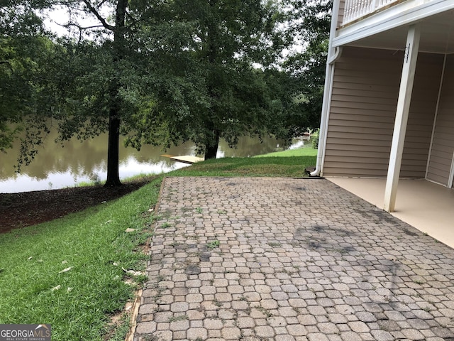 exterior space with a lawn, a water view, and a patio