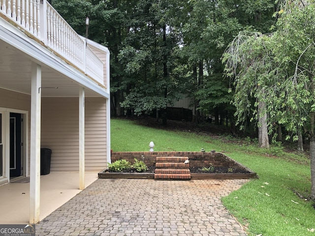 view of yard with a balcony and a patio