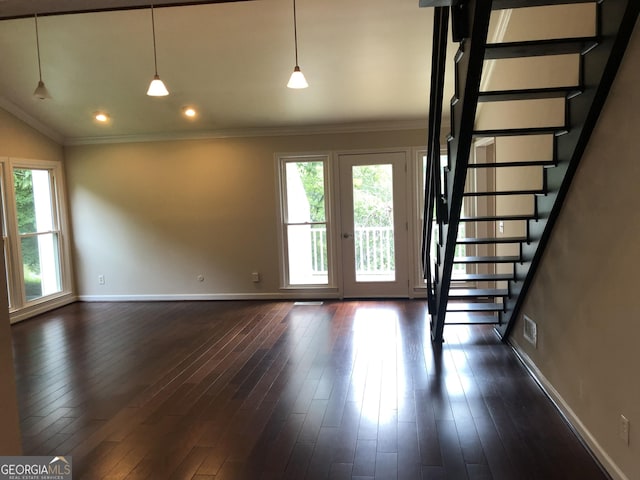 interior space with dark wood-type flooring, a wealth of natural light, and ornamental molding