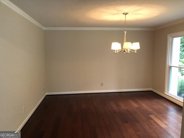 spare room featuring dark hardwood / wood-style floors, crown molding, and a chandelier