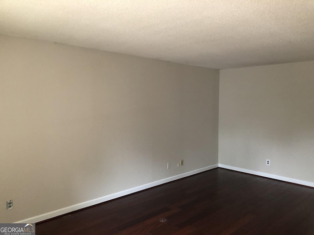 spare room featuring hardwood / wood-style floors and a textured ceiling