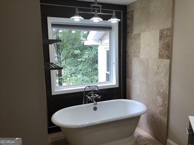 bathroom featuring a bathtub and tile walls