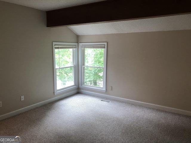 empty room with light carpet and lofted ceiling with beams