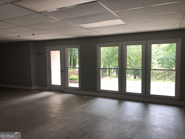 doorway to outside featuring a drop ceiling