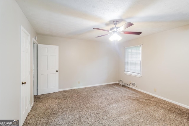 carpeted spare room with ceiling fan