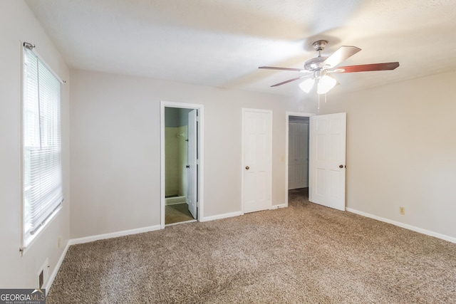 unfurnished bedroom featuring ceiling fan, carpet flooring, and connected bathroom