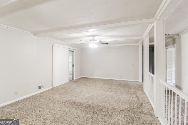 carpeted spare room with ceiling fan, crown molding, and beamed ceiling