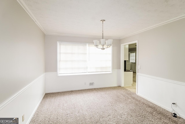 spare room with ornamental molding, light colored carpet, and a notable chandelier