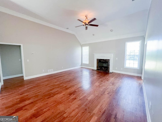 unfurnished living room with crown molding, wood-type flooring, vaulted ceiling, ceiling fan, and a high end fireplace