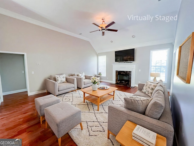 living room with hardwood / wood-style flooring, ornamental molding, lofted ceiling, and a fireplace