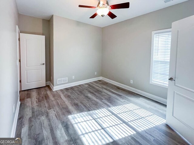 spare room with ceiling fan, light wood-type flooring, and a wealth of natural light