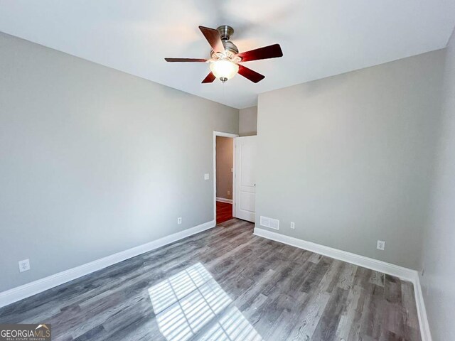 spare room with hardwood / wood-style floors and ceiling fan