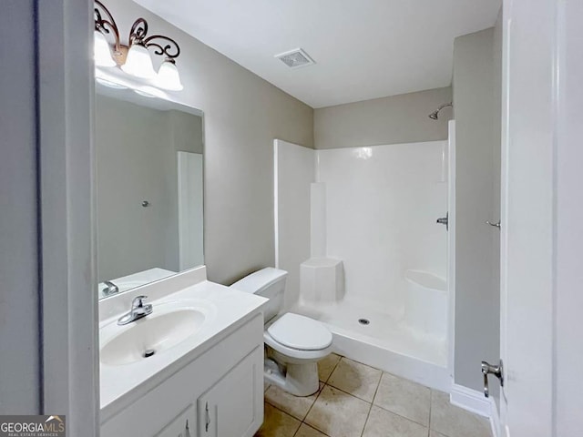 bathroom featuring a shower, vanity, tile patterned floors, and toilet