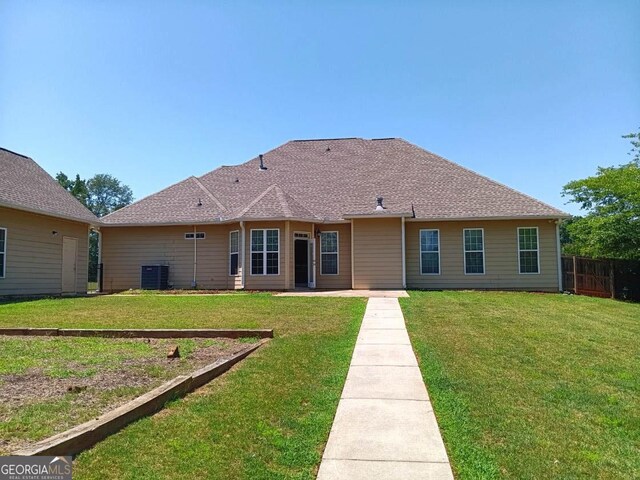 back of property featuring a yard and central AC unit