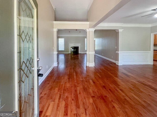 entrance foyer featuring decorative columns, wood-type flooring, ceiling fan, and crown molding