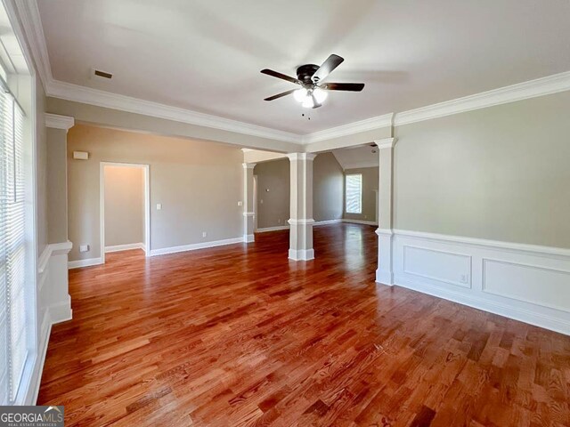 unfurnished room featuring hardwood / wood-style floors, crown molding, decorative columns, and ceiling fan