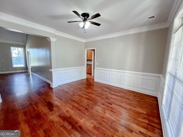 unfurnished room with decorative columns, ornamental molding, hardwood / wood-style floors, and ceiling fan