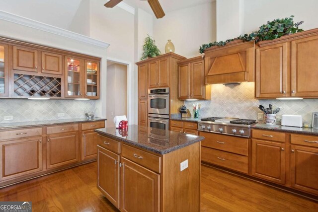 2491 Isles Of St Marys Way, Saint Marys, GA 31558 - kitchen with appliances with stainless steel finishes, wood finished floors, a center island, backsplash, and high vaulted ceiling