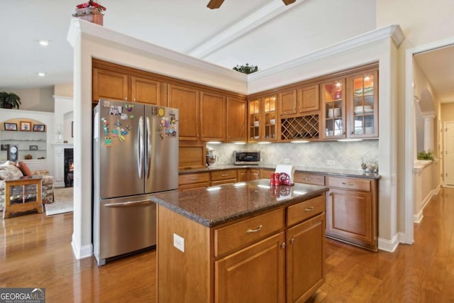 kitchen featuring a center island, ceiling fan, wood-type flooring, and stainless steel fridge