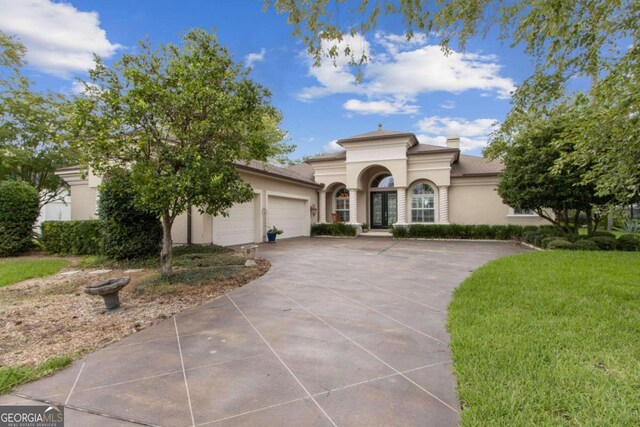 2491 Isles Of St Marys Way, Saint Marys, GA 31558 - mediterranean / spanish house with stucco siding, french doors, a garage, concrete driveway, and a chimney