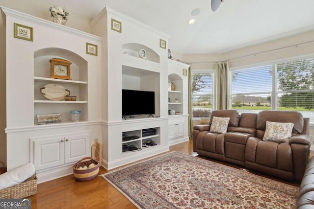 living room featuring built in features, ornamental molding, and wood-type flooring