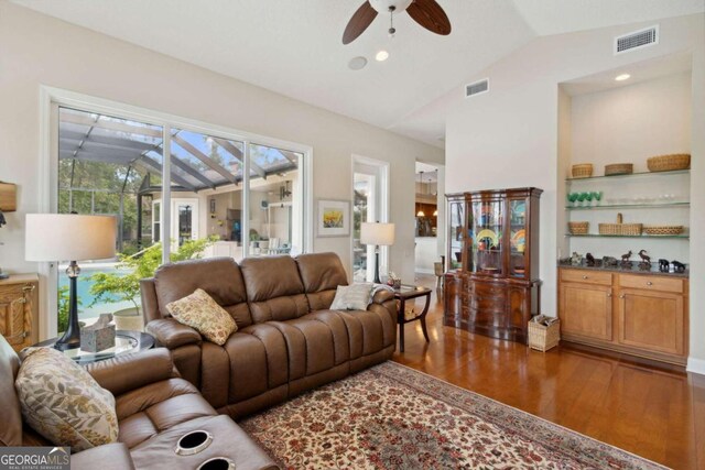 living room with ceiling fan, dark hardwood / wood-style flooring, and vaulted ceiling